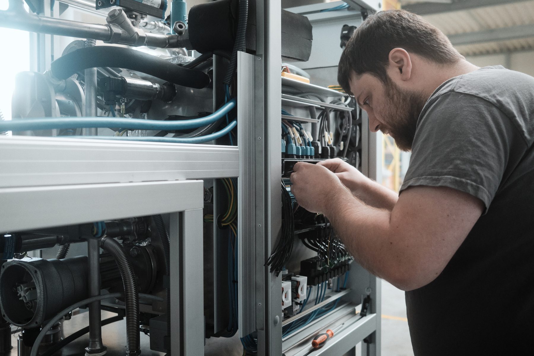 Techniker verdrahtet den Schaltschrank einer LÖMI Anlage bei der Inbetriebnahme